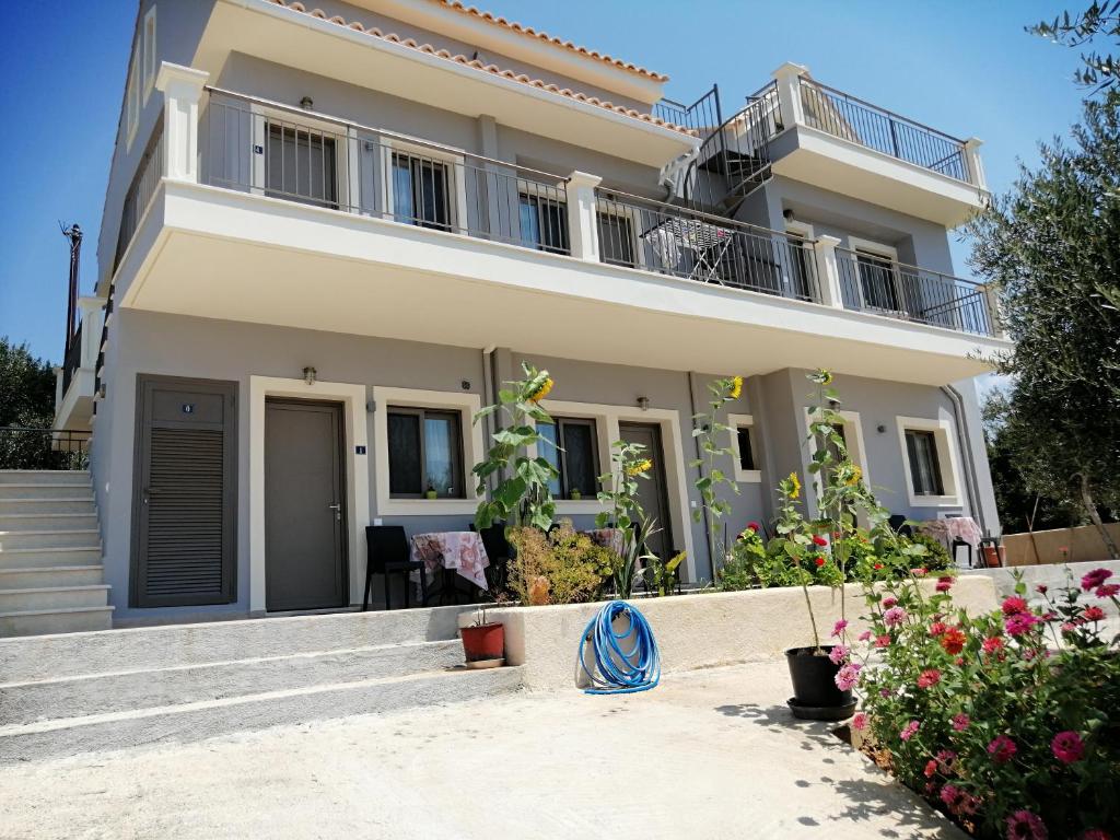 a white house with a balcony and some flowers at TA DIDYMAKIA APARTMENTS. in Argostoli