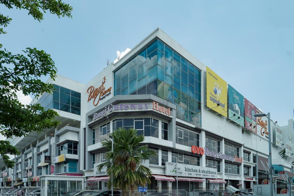 a large building with a palm tree in front of it at Super OYO 90729 New Bangi Gateway Hotel in Bangi
