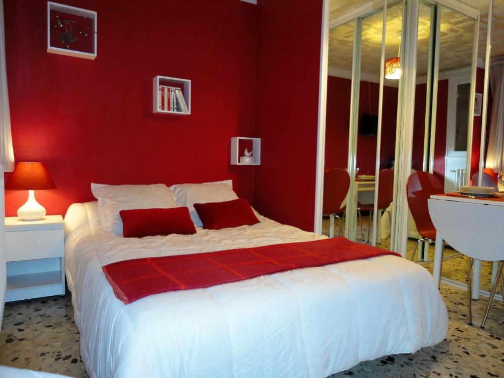 1 dormitorio rojo con 1 cama y pared roja en Studio Framboise proche Paris et Disneyland, en Gagny