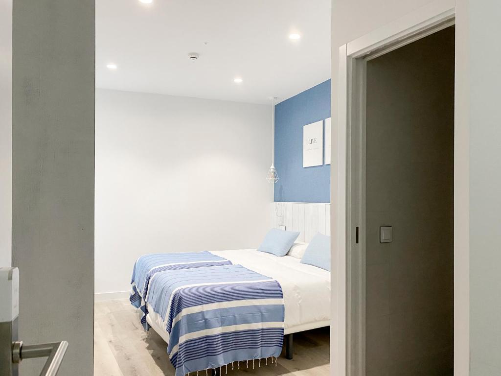 a bedroom with a bed with a blue accent wall at Nerja Casual Rooms in Nerja