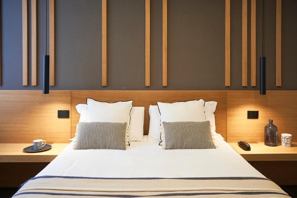 una camera da letto con un grande letto bianco con due cuscini di Central Lodge Hotel a Roma