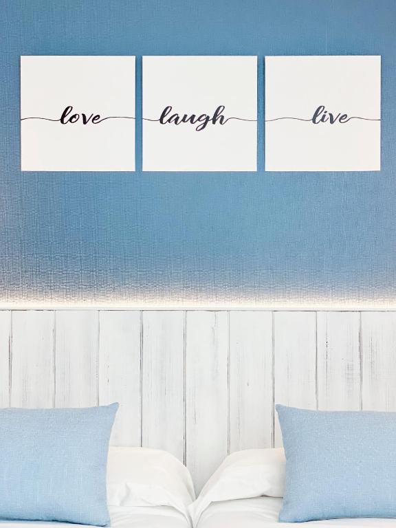 a bed with three pieces of paper with the words love yourself at Nerja Casual Rooms in Nerja