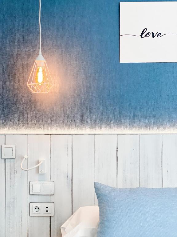 a bedroom with a light hanging over a bed at Nerja Casual Rooms in Nerja