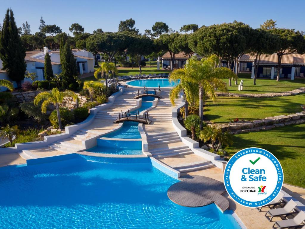 a large pool of water with trees and palm trees at Pestana Vila Sol Golf & Resort Hotel in Vilamoura