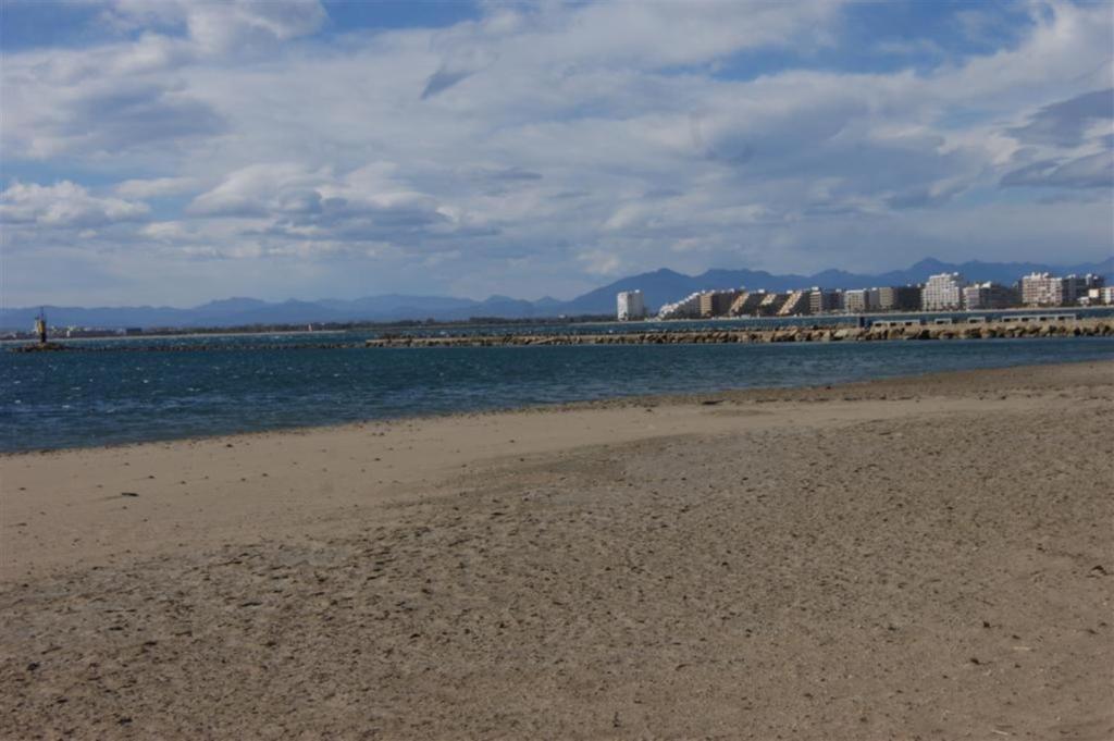 una playa de arena con edificios en el fondo en Agi Sant Isidre, en Roses