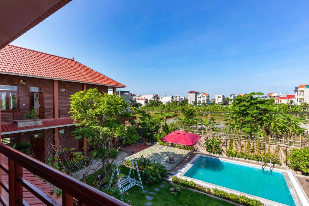 een balkon met uitzicht op een zwembad en een huis bij MH Cherish Homestay in Ninh Binh