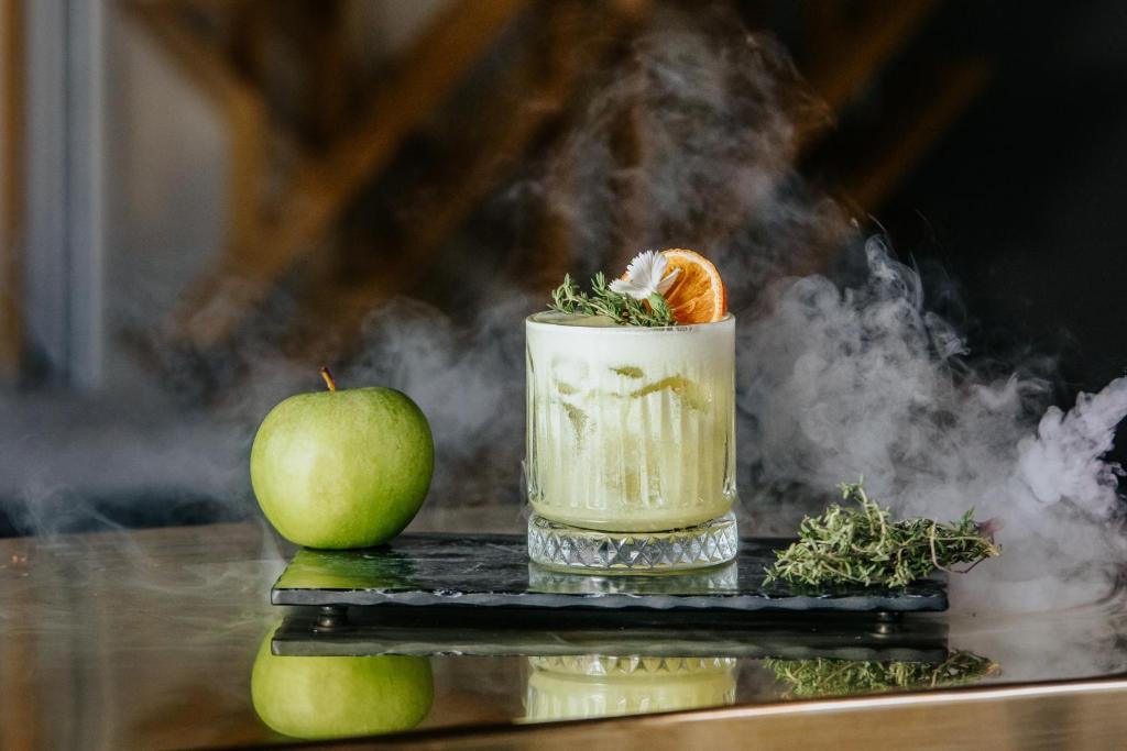 a drink and an apple on a table with smoke at Napa Plaza Hotel (Adults Only) in Ayia Napa