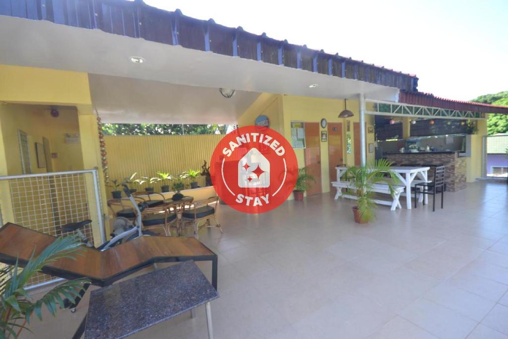 a restaurant with tables and chairs and a red sign at Las Residencias Bed And Breakfast in Puerto Princesa City