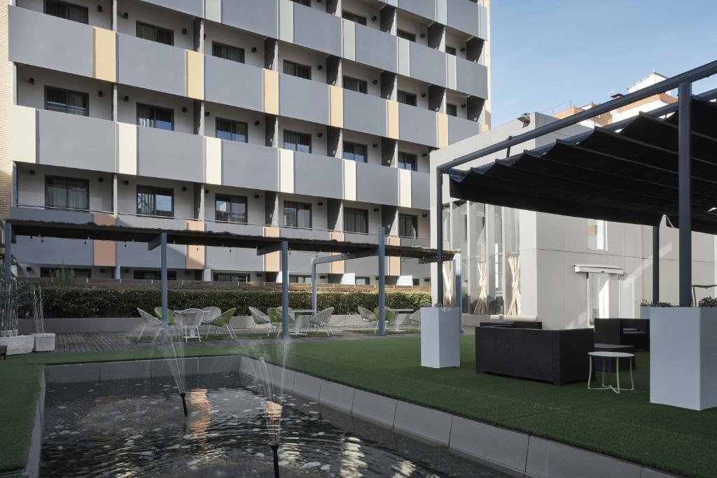 un hôtel avec une piscine en face d'un bâtiment dans l'établissement Vincci Zaragoza Zentro, à Saragosse