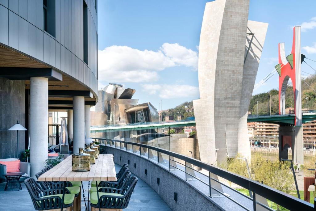 a balcony with a table and chairs on a building at Vincci Consulado de Bilbao in Bilbao