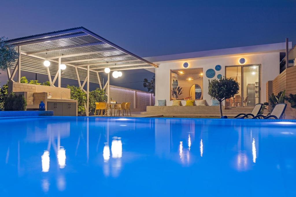 a swimming pool in front of a house at night at Gaia Blue Villa in Kolymbia