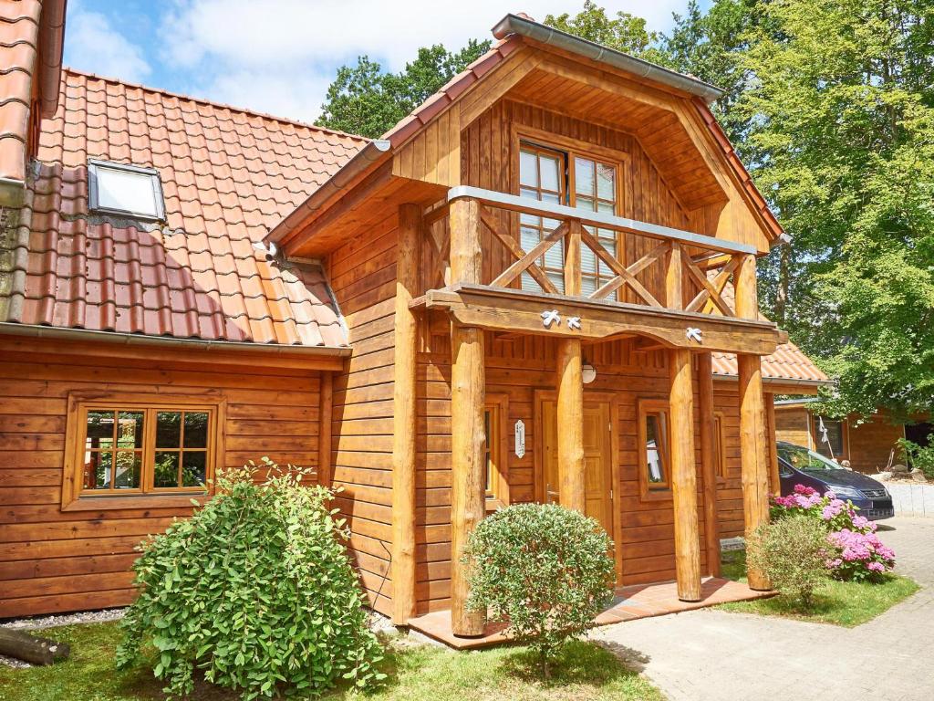 een houten huis met een schilddak bij Strandschlösschen Sellin - Haushälfte 1 in Ostseebad Sellin