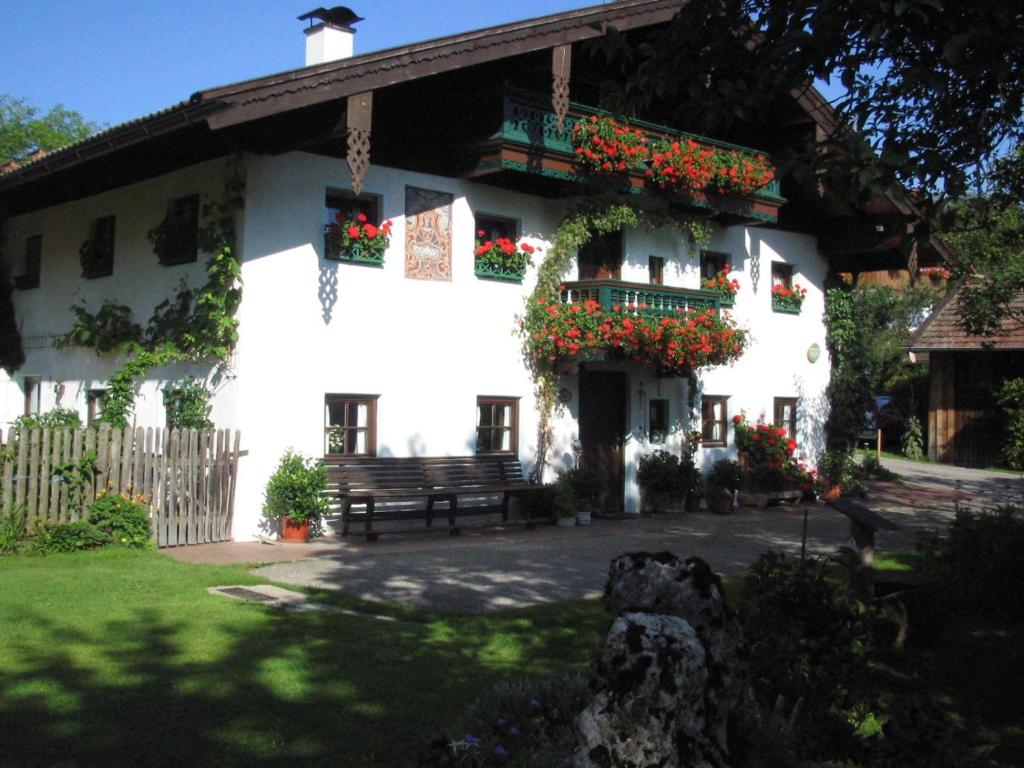 a white house with flower boxes and a bench at Ferienwohnung Aicher Sagberg in Frasdorf