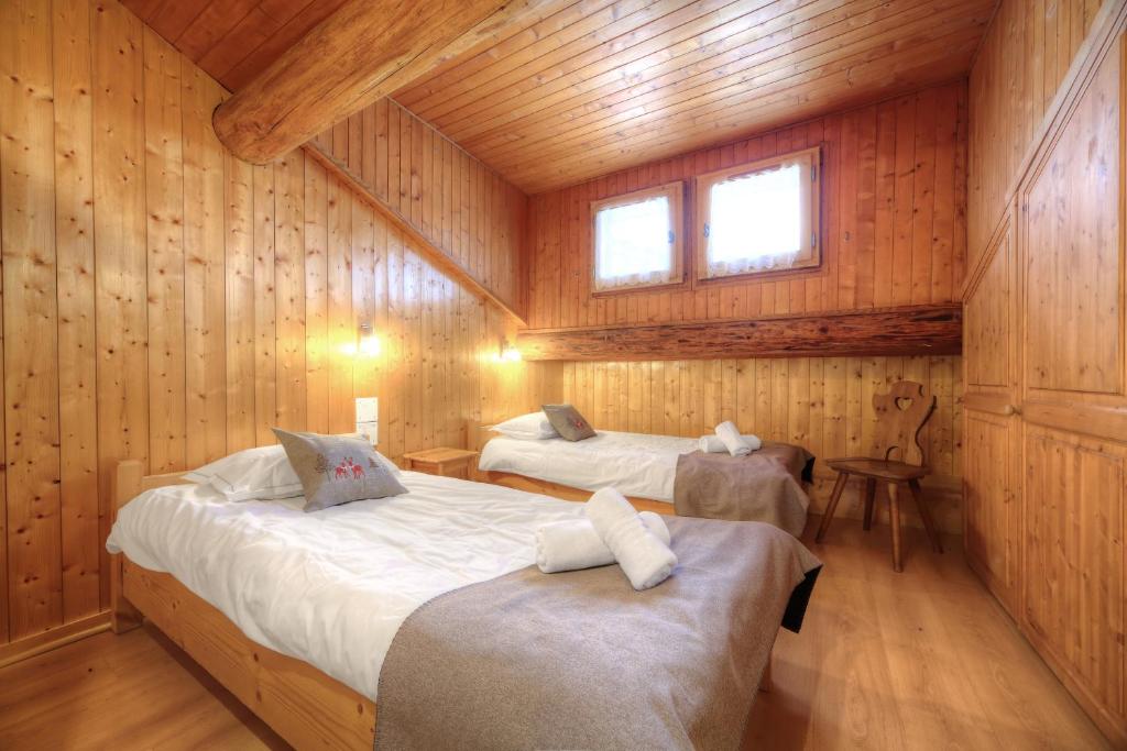 a bedroom with two beds in a wooden cabin at Chalet-Hôtel de l&#39;Etape in Les Contamines-Montjoie