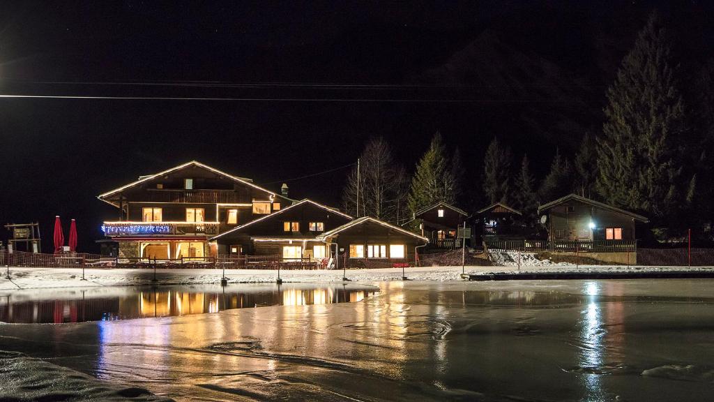 a house at night with a pond in front of it at Chalet-Hôtel de l&#39;Etape in Les Contamines-Montjoie