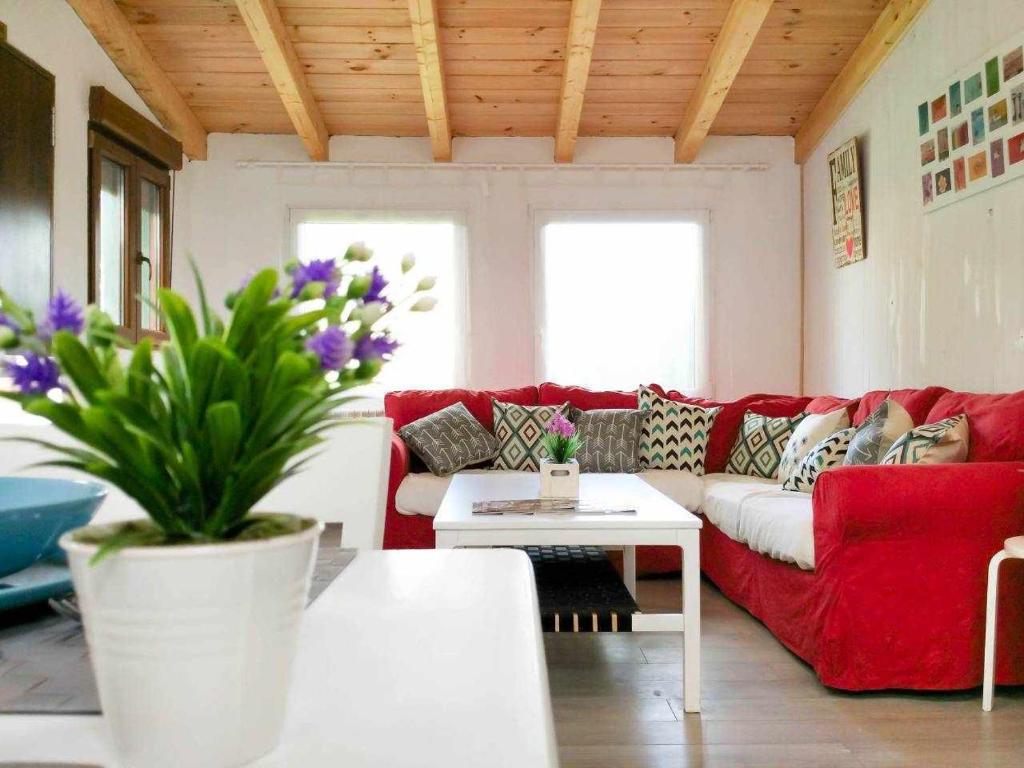 - un salon avec un canapé rouge et une table dans l'établissement LA CASITA DEL JARDiN, à Villaverde de Arriba