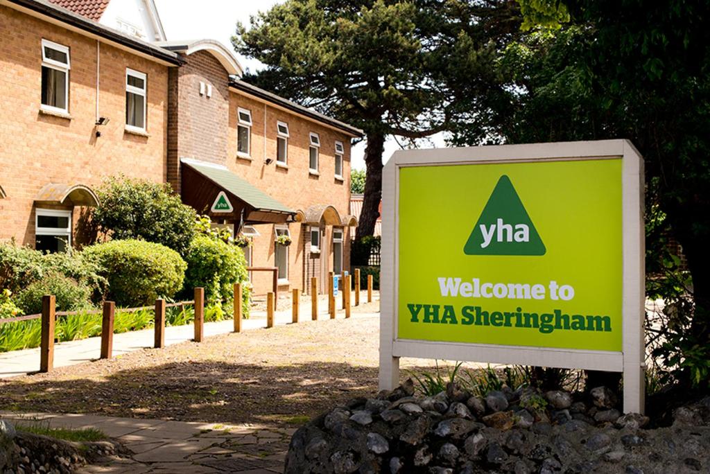 una señal de bienvenida frente a un edificio en YHA Sheringham, en Sheringham
