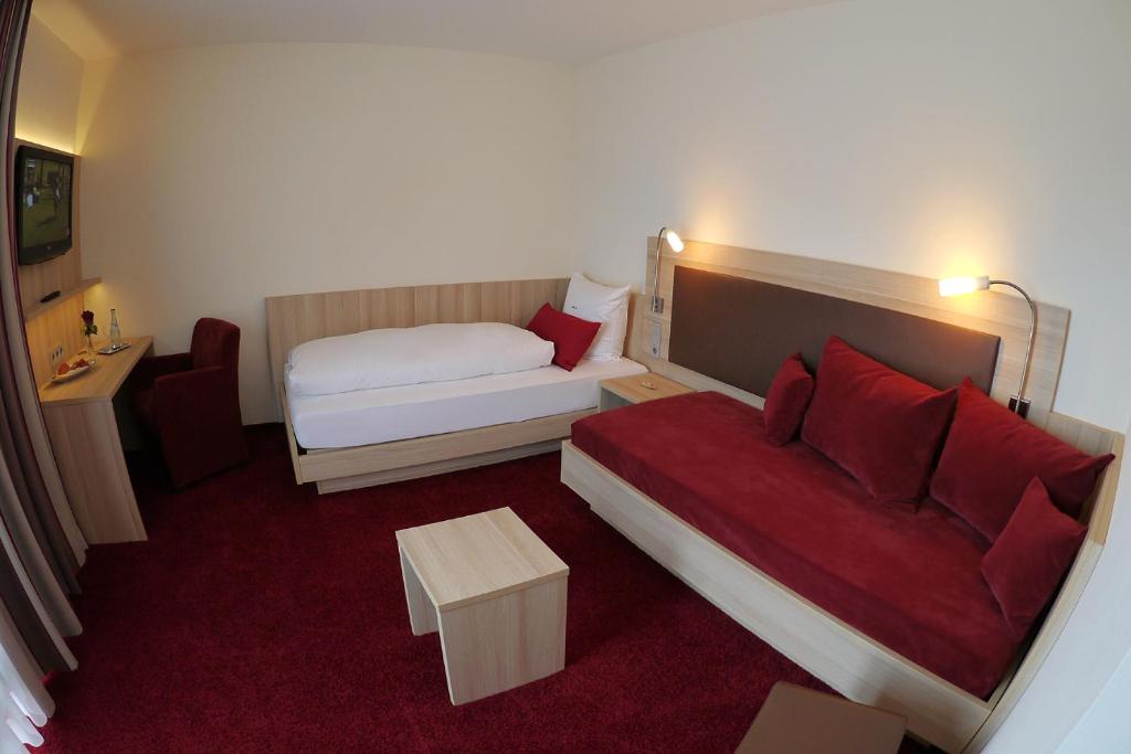 a hotel room with a bed and a couch at Gästehaus Rössle in Weinstadt