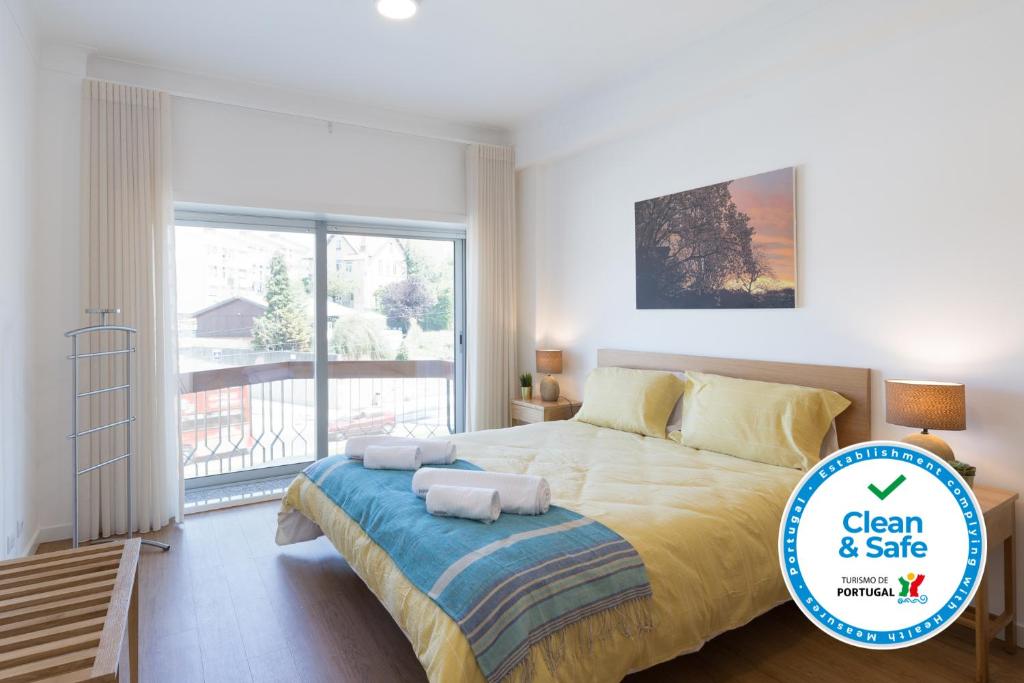 um quarto com uma cama grande e uma varanda em Lovely Flat with Charming Terrace by Host Wise em Vila Nova de Gaia