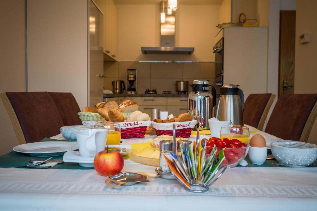 a table with a breakfast of eggs and fruit on it at Rene's B&B in Kerkrade