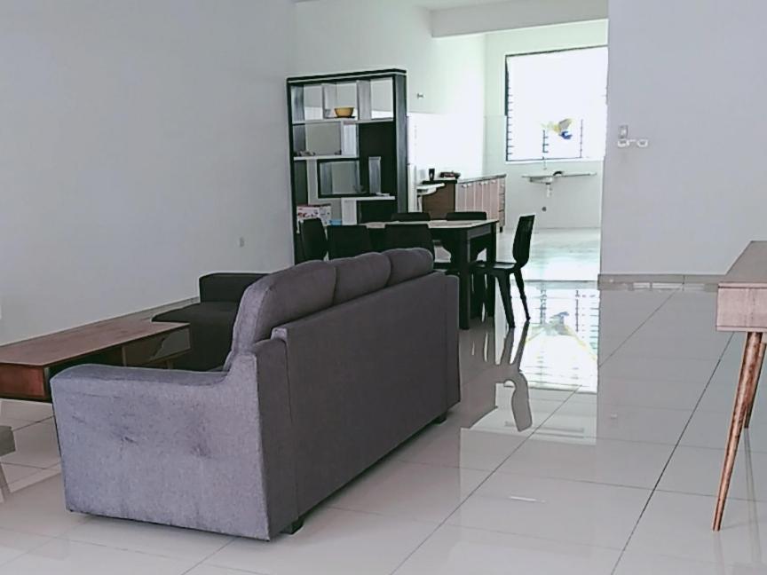 een woonkamer met een bank en een tafel bij FangFei Homestay in Seremban