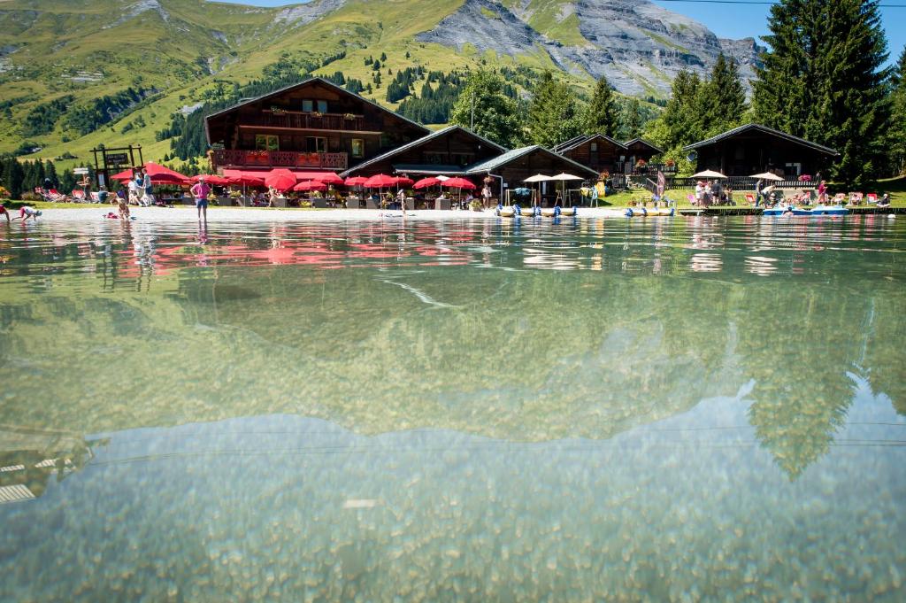 a reflection of a lodge in the water of a lake at Chalet-Hôtel de l&#39;Etape in Les Contamines-Montjoie