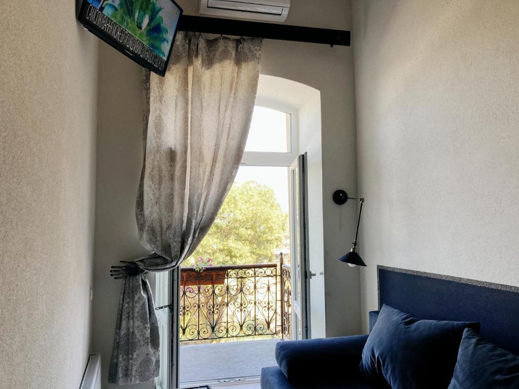 a living room with a window and a blue couch at Marinesko Apartments in Odesa