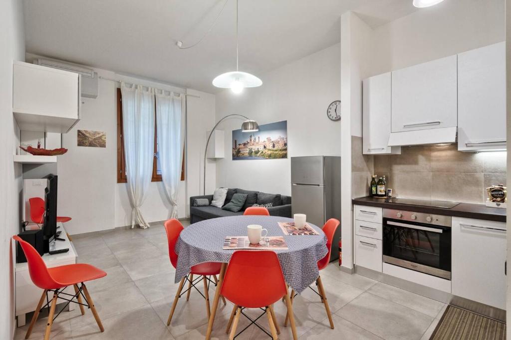une cuisine et une salle à manger avec une table et des chaises rouges dans l'établissement BellaMantova 2, à Mantoue
