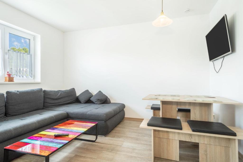 ein Wohnzimmer mit einem Sofa und einem Tisch in der Unterkunft Ferienwohnung Eyrich Eg in Lindau