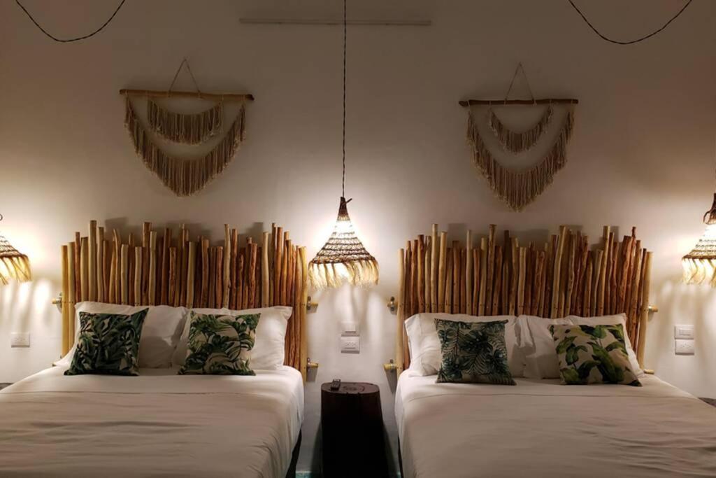 2 bedden in een kamer met kroonluchters bij Apartament, the best location, 60 mts from the sea in Cozumel