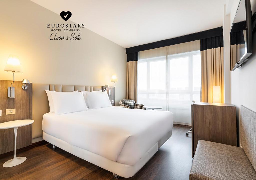 a hotel room with a large bed and a large window at Eurostars Atlántico in A Coruña