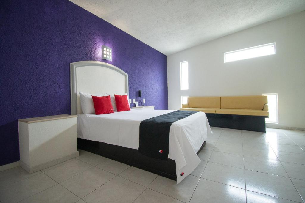 a bedroom with a large bed with red pillows at Hotel Rivoli in León