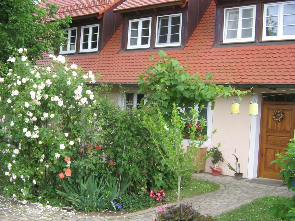 un jardín frente a una casa con flores blancas en Ferienwohnungen Wastl Fränkische Schweiz, en Hiltpoltstein