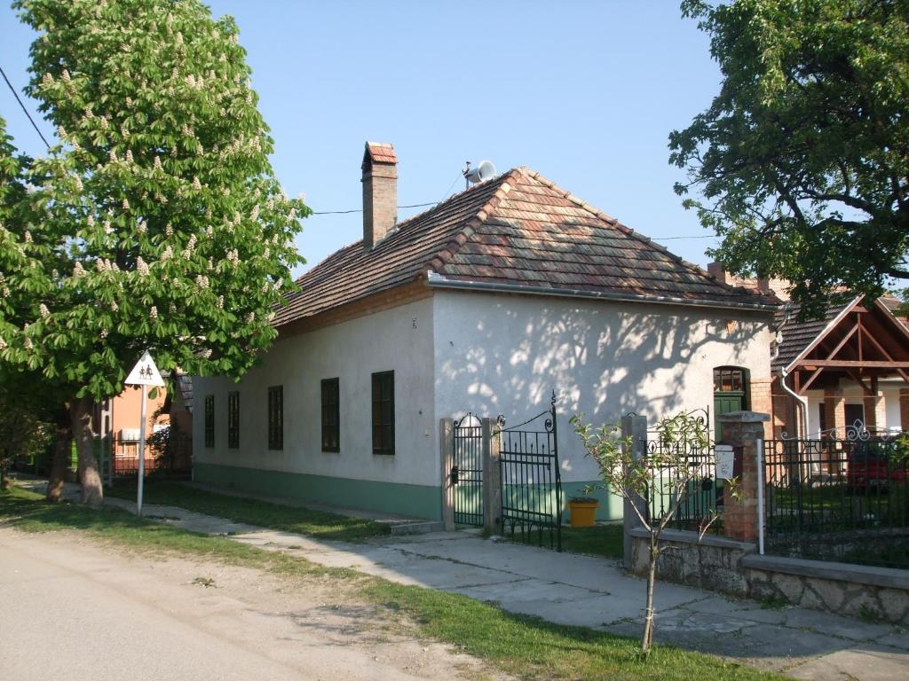 una vieja casa blanca con una valla delante en Bike Stop Duna en Dunaszentmiklós