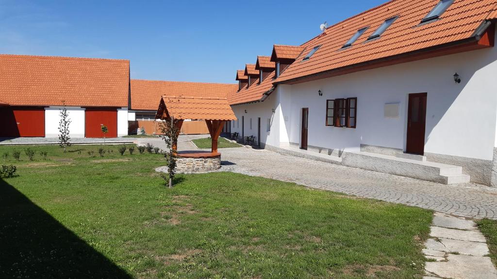 een rij gebouwen met rode daken en een tuin bij Martinův dvůr in Pilsen