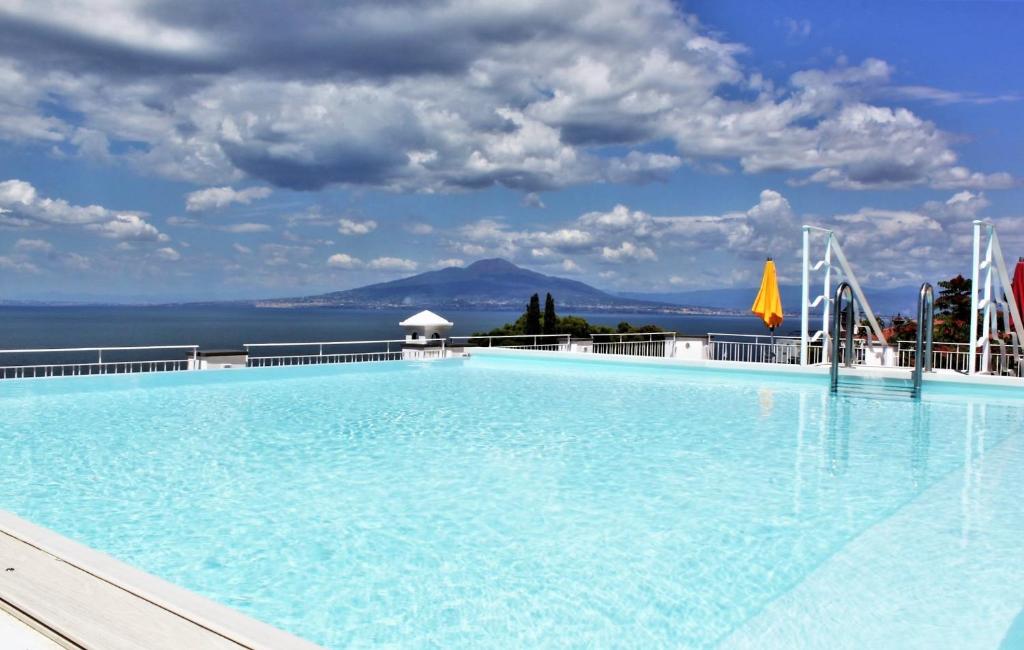 uma grande piscina com vista para o oceano em Boutique Hotel Helios em Sorrento