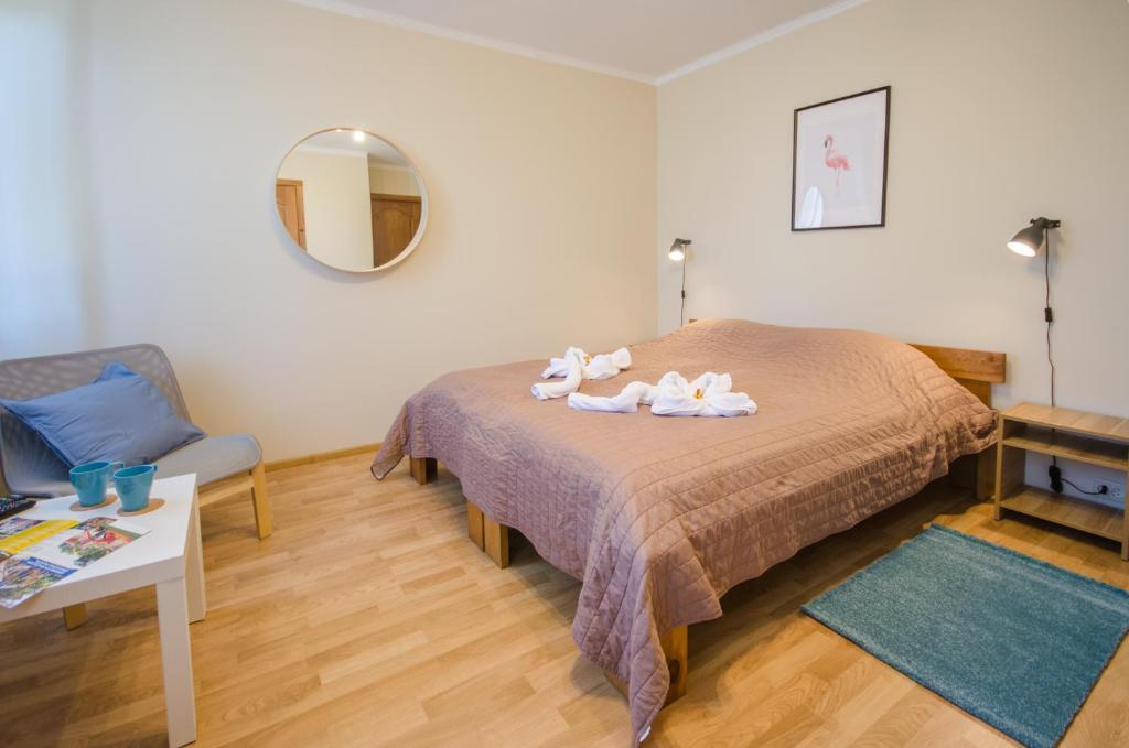 a bedroom with a bed with two towels on it at Veldzes Nams in Ventspils