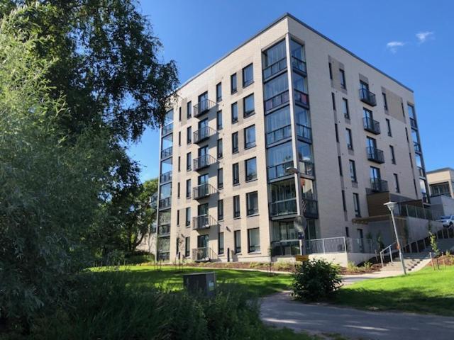 un gran edificio blanco frente a un campo de césped en Stylished and Bright studio apartment, en Helsinki