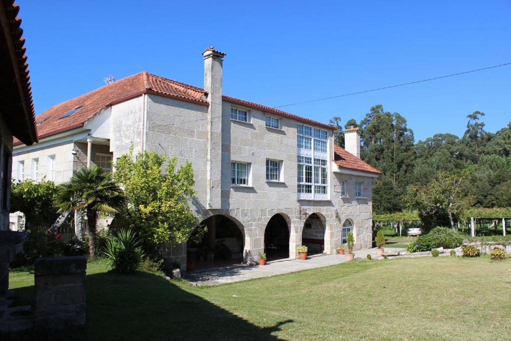 a large brick building with a large window at Os Areeiros Turismo Rural & Bodega in Santa Cristina de Cobres