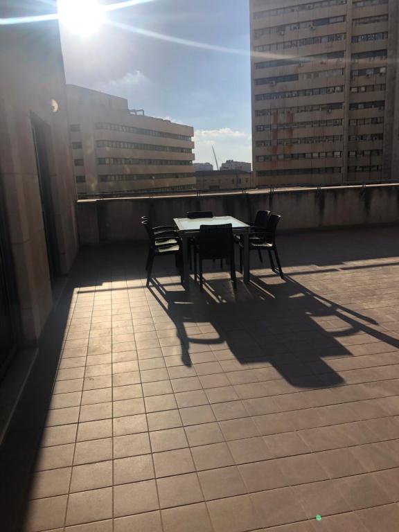 a table and chairs on the roof of a building at Beautiful 3 BDR Heart of JLM -Modern with Huge Balcony in Jerusalem