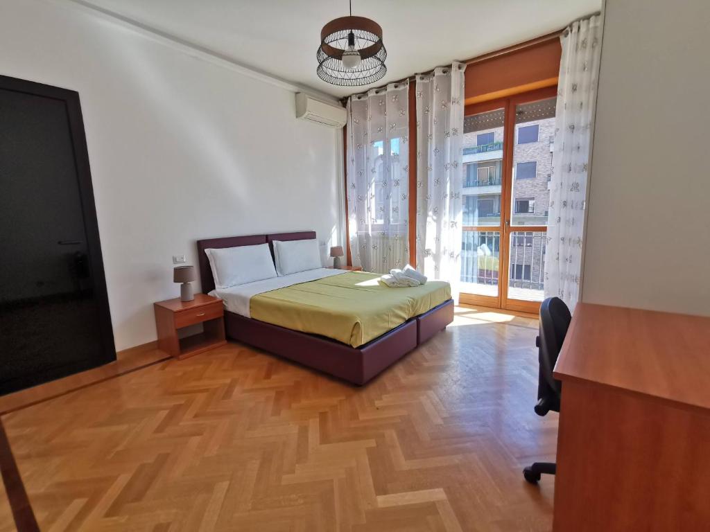 Schlafzimmer mit einem Bett, einem Schreibtisch und einem Fenster in der Unterkunft Pergolesi Apartments in Mailand