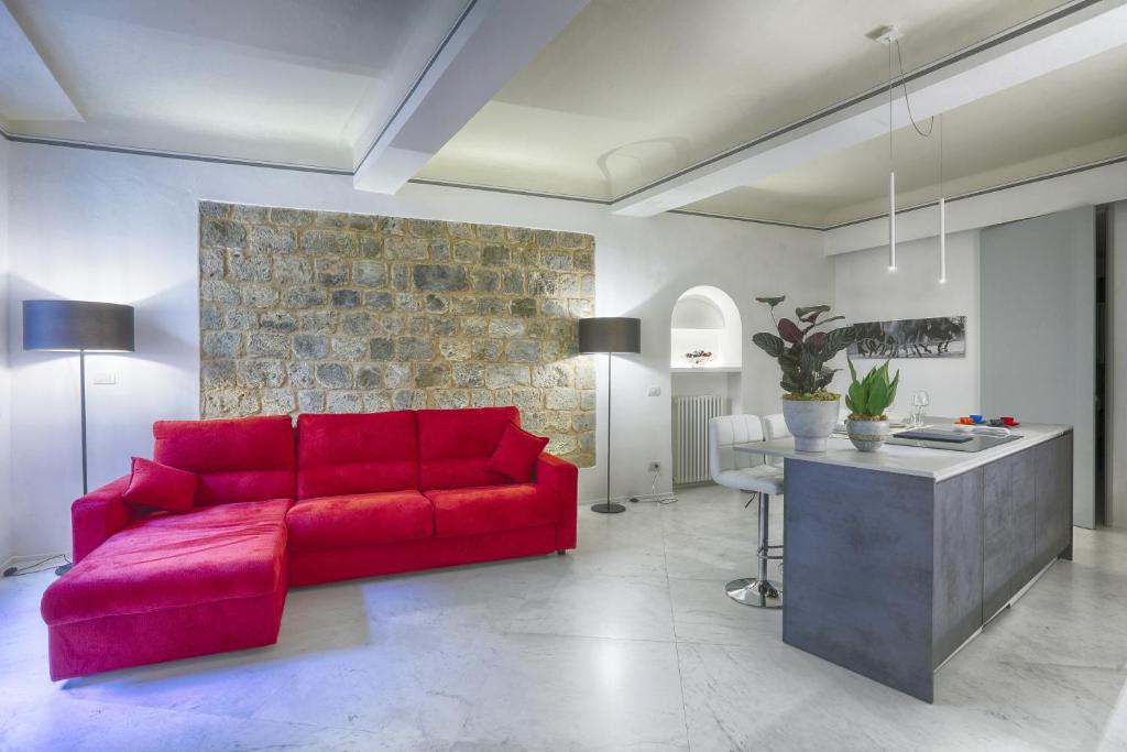 sala de estar con sofá rojo y mesa en Dimora storica - Palazzo del Taja en Siena