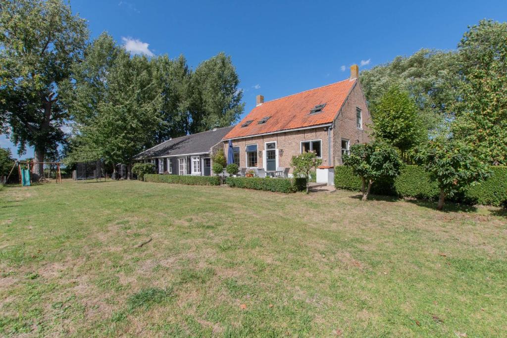 een huis met een grote tuin ervoor bij Landelijk gelegen familieboerderij in Oudelande