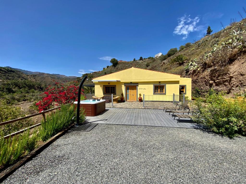 ein gelbes Haus auf einem Hügel mit einem Zaun in der Unterkunft La cara Luna in Santa Brígida