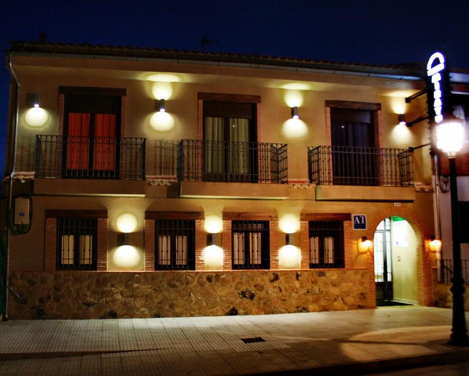 un bâtiment avec des lumières sur son côté la nuit dans l'établissement Apartamentos Turisticos Mirayuste, à Guadalupe