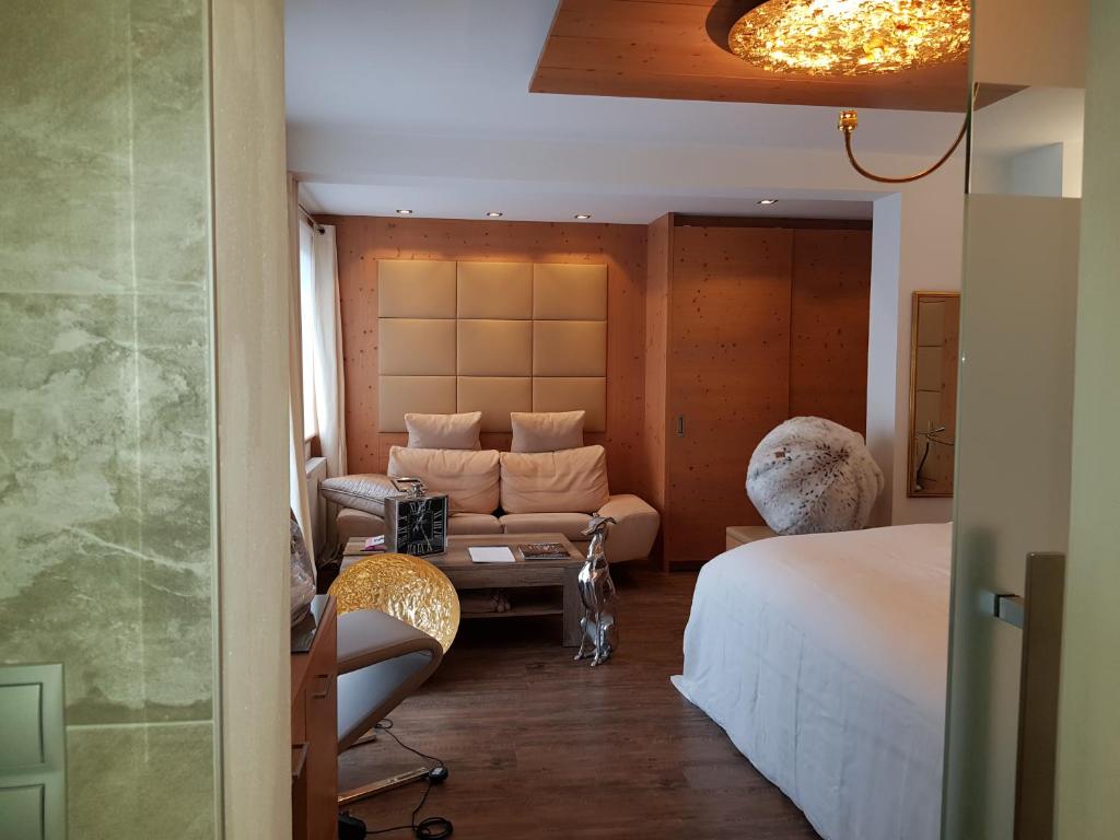 a hotel room with a bed and a couch at Hotel Vergeiner in Seefeld in Tirol