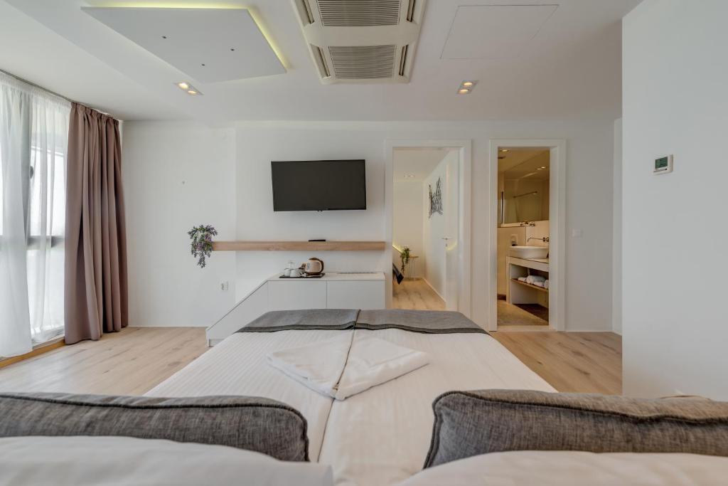 a bedroom with a bed and a tv on the wall at Hotel Pax in Split