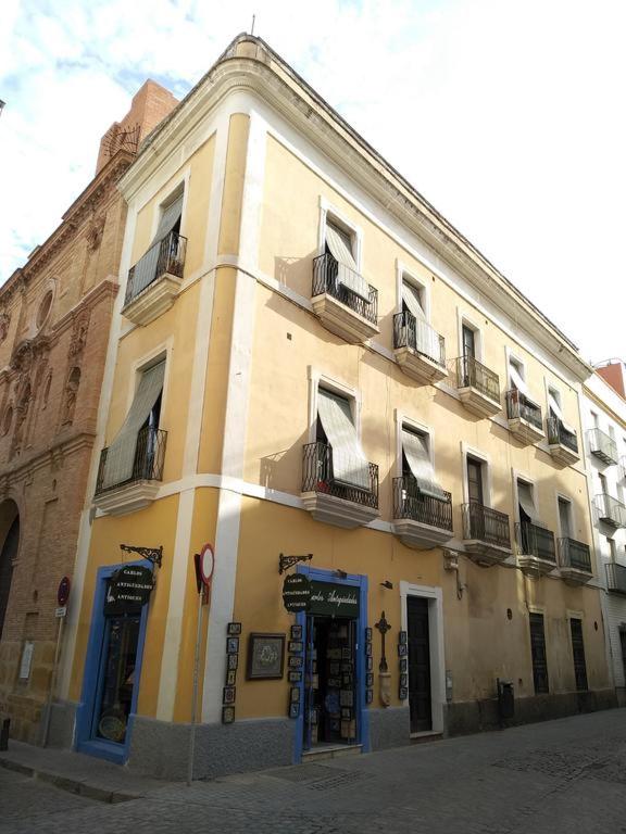 un edificio amarillo con ventanas y balcones en una calle en Apartamento Centro Encarnación 1º I en Sevilla