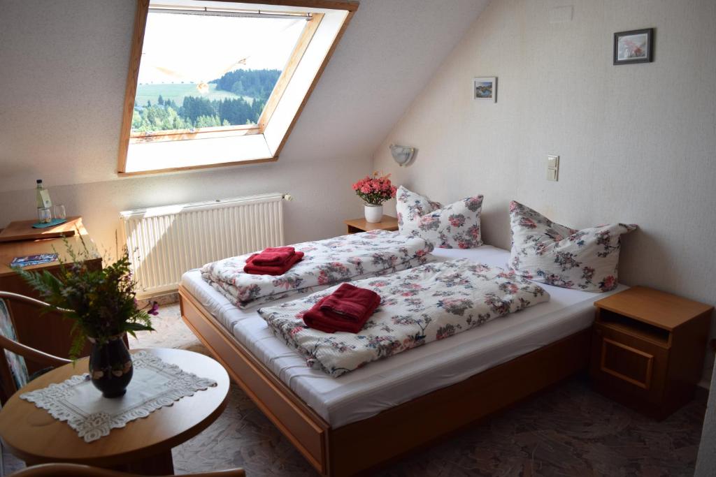 a bedroom with two beds with pillows and a window at Hotel Carola in Schönheide