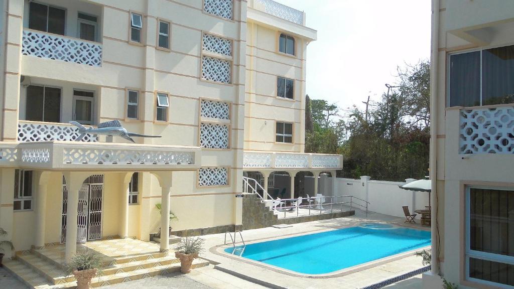 an external view of a building with a swimming pool at Pavilion Holiday Resort in Bamburi